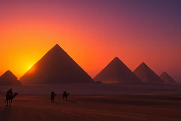 Pyraminds towering under a vibrant sunrise, evoking ancient wonders and historical significance.